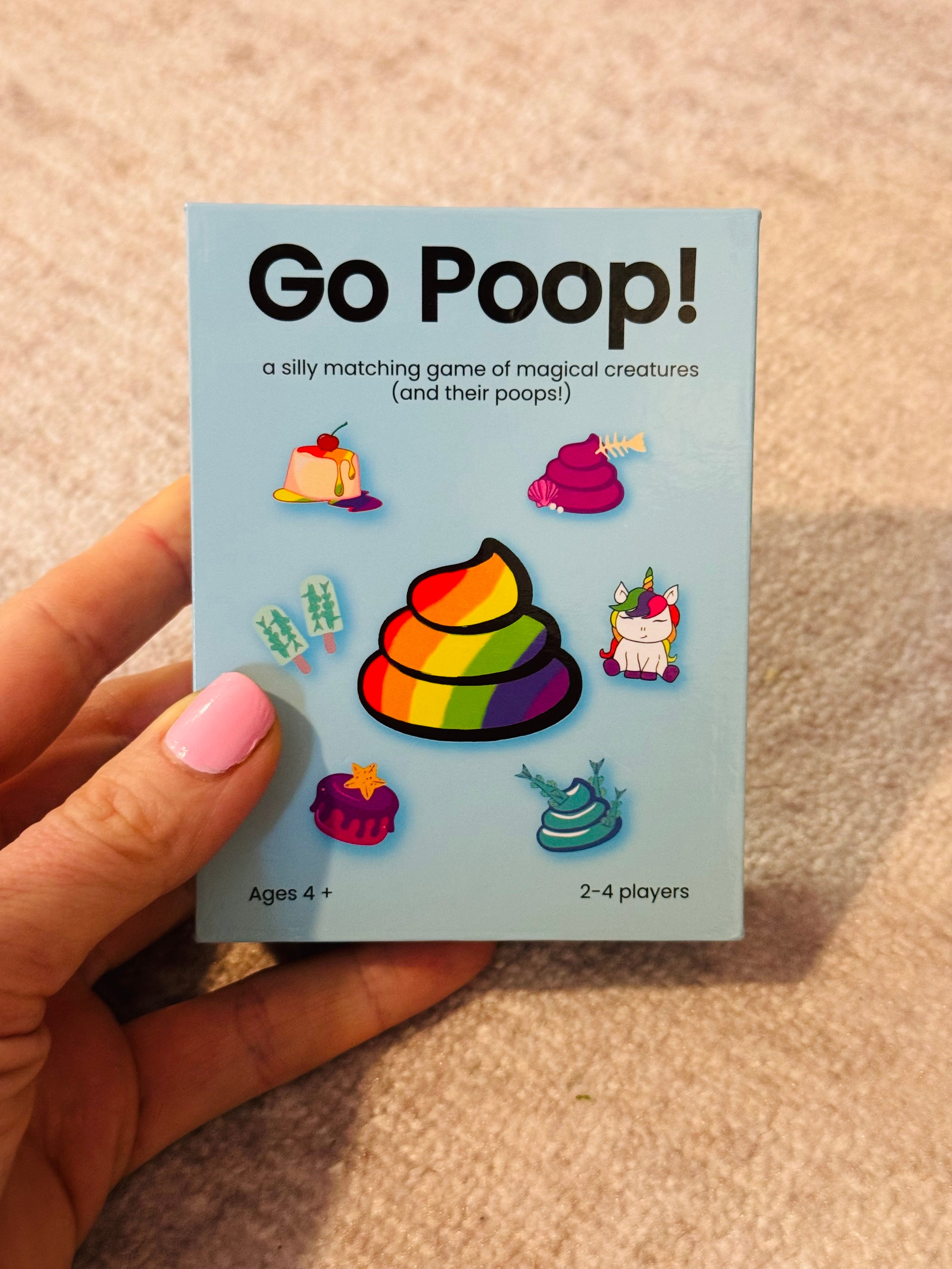 game box in hand with pink nail polish